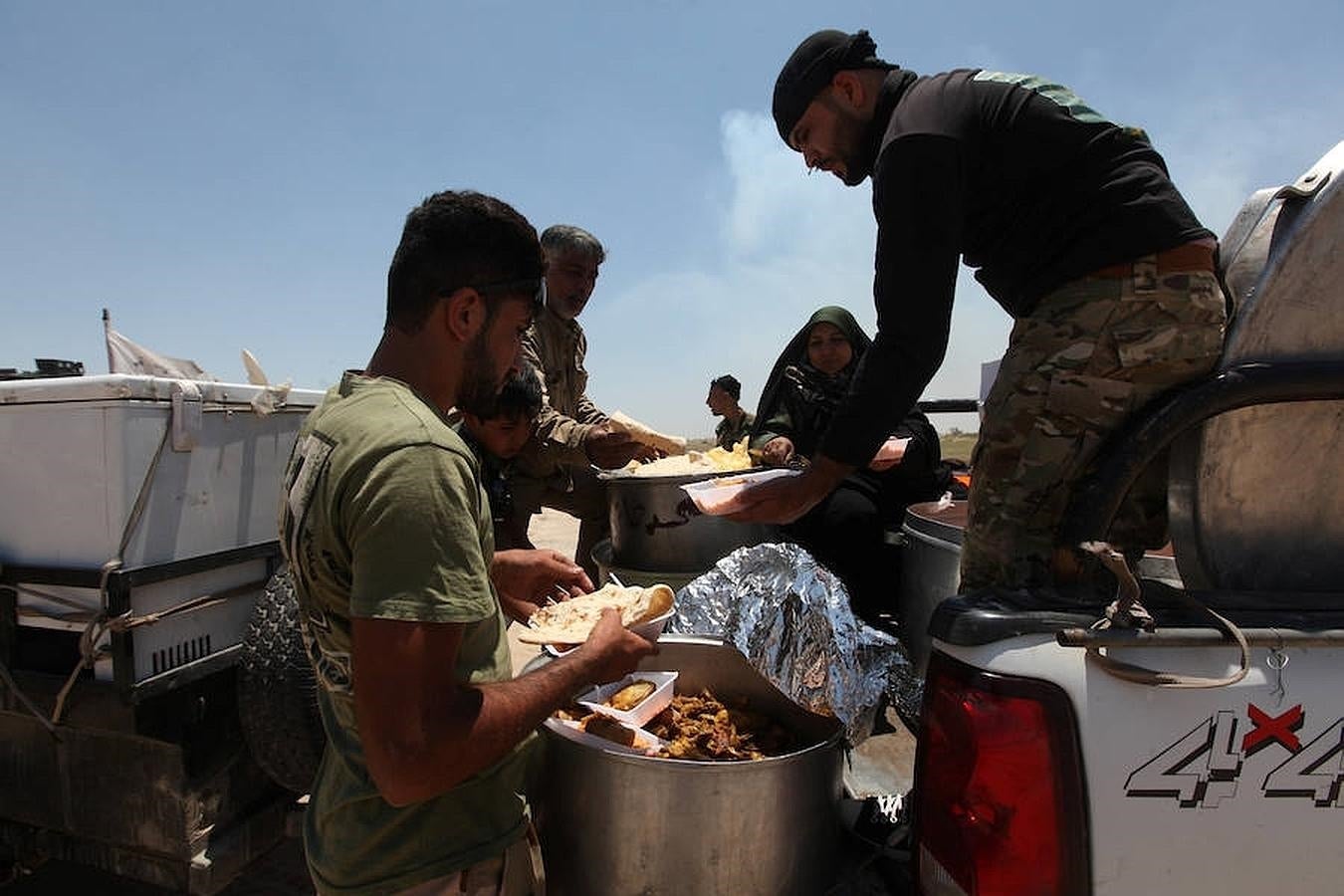 Miembros de las fuerzas de seguridad iraquíes toman su comida. 