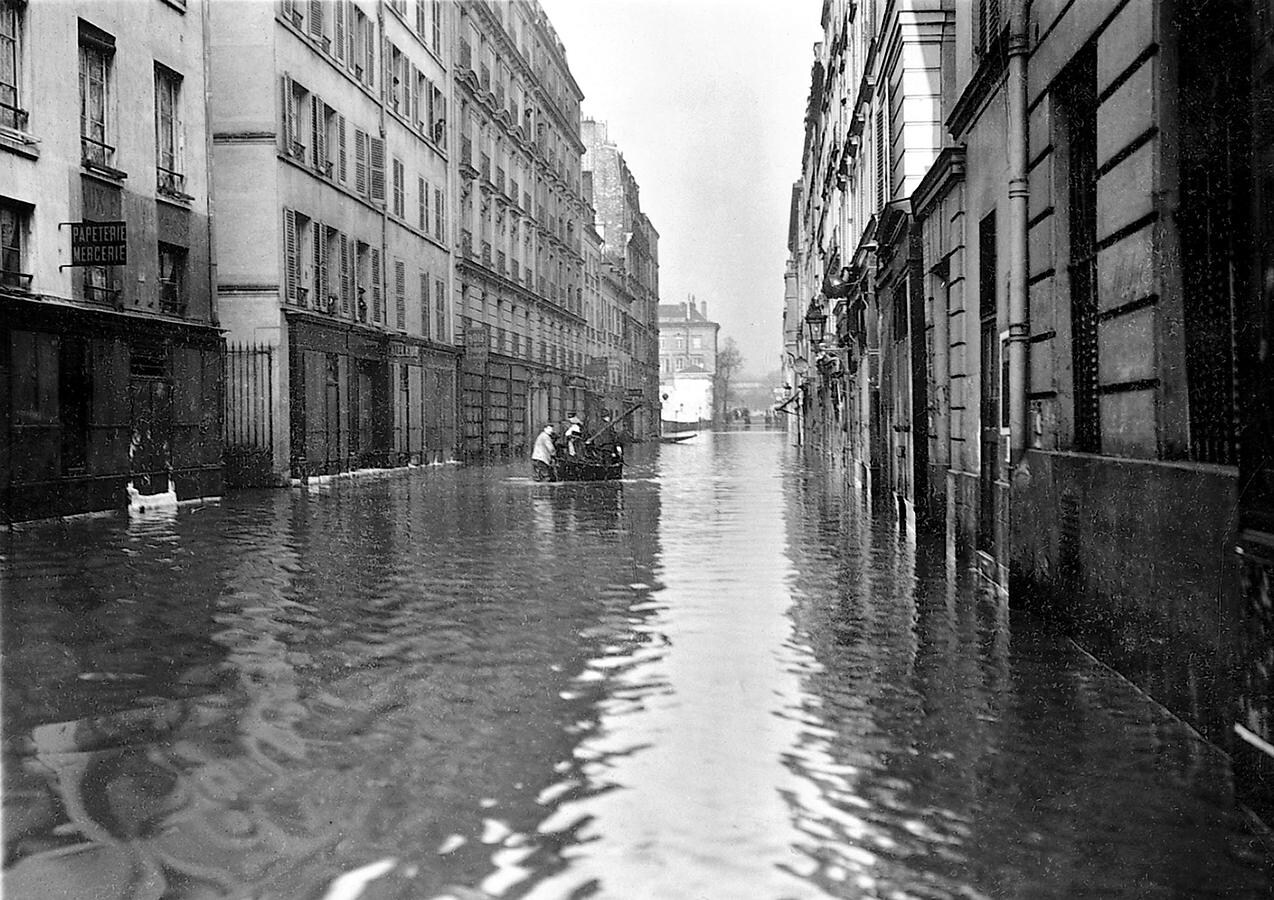 Una barca atraviesa una de las calles de París durante las inundaciones de 1910