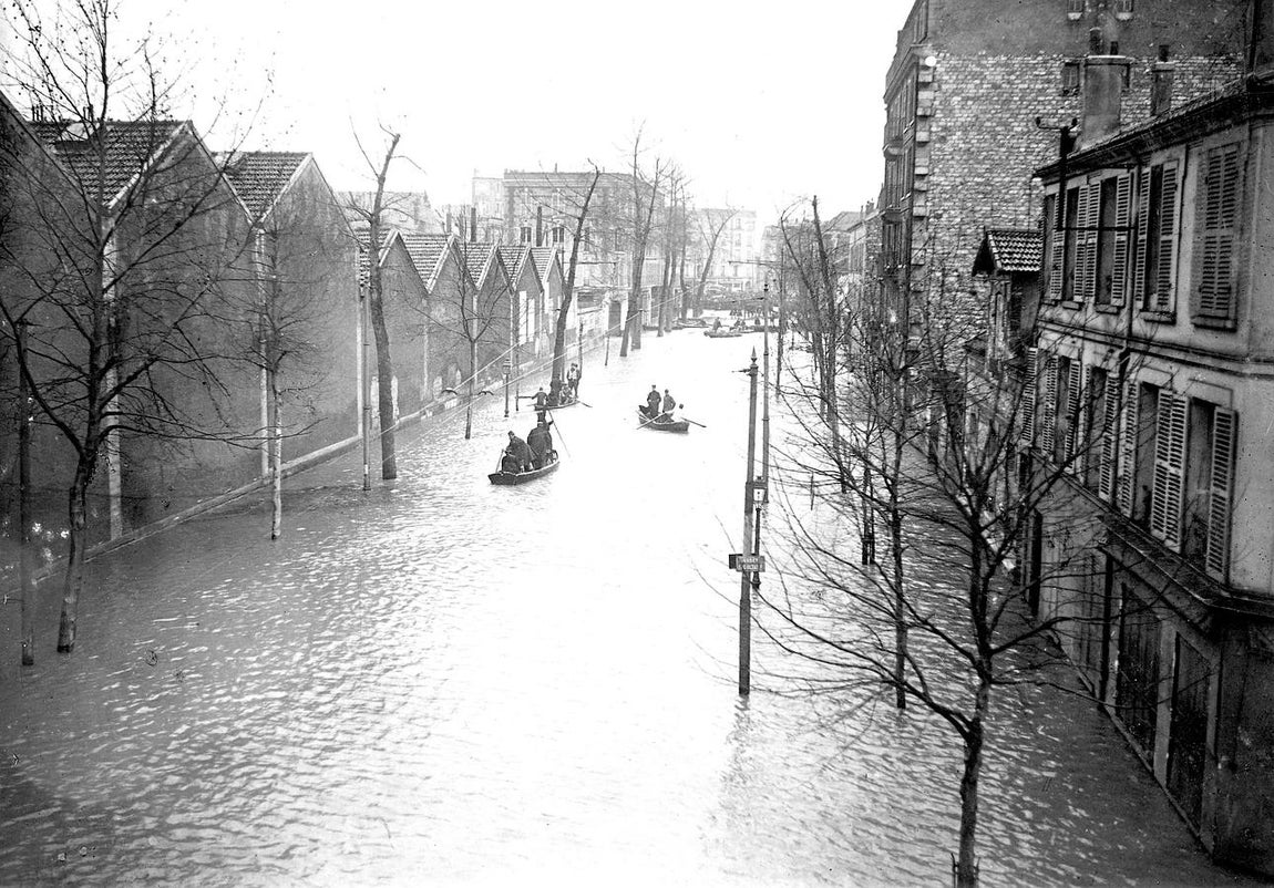 Un grupo de barcas atraviesan una calle inundada en 1910. 
