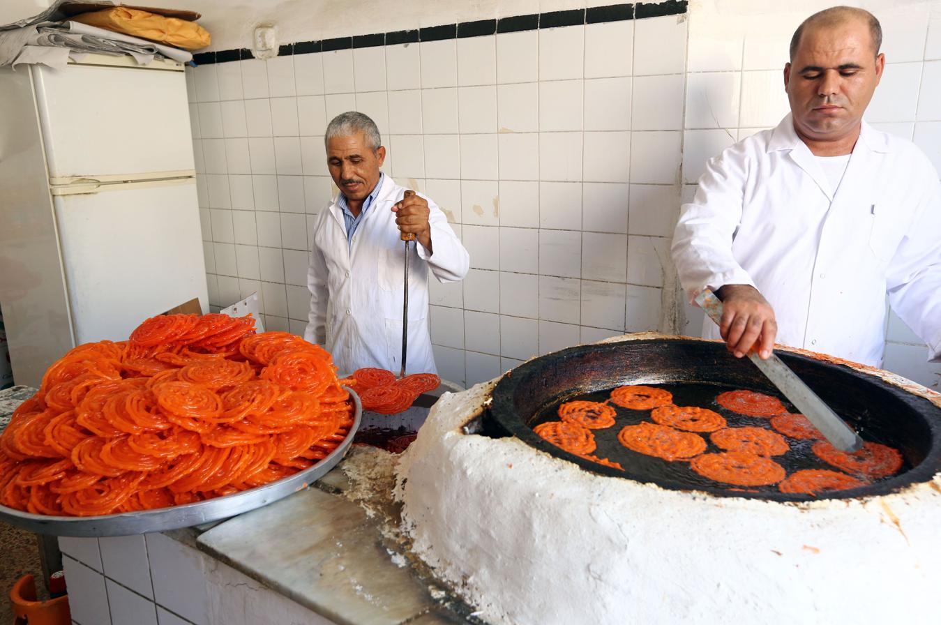 Un grupo de hombres libios preparan dulces tradicionales en Trípoli, antes del Iftar o fin del ayuno 