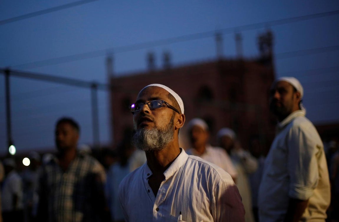 Unos musulmanes miran al cielo, en busca de la luna creciente, en la víspera del comienzo del mes sagrado del islam, este lunes en la gran mezquita de Delhi. 