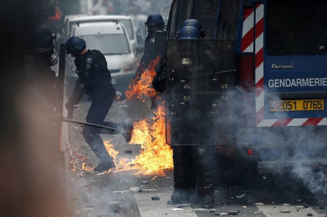 Varios policías huyen tras el lanzamiento de un cóctel mólotov durante la manifestación. 