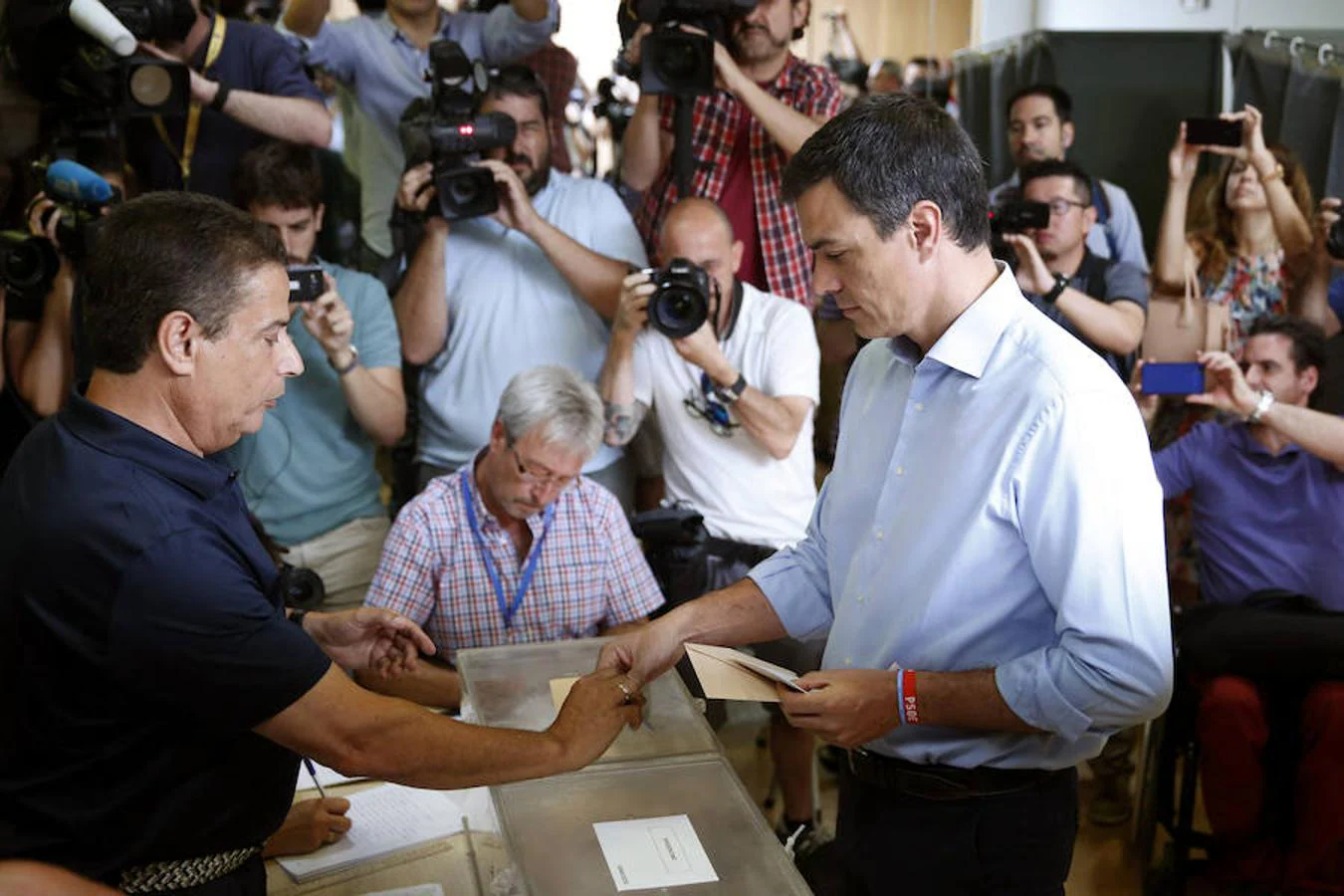 Sánchez recoge su DNI antes de introducir su voto en la urna