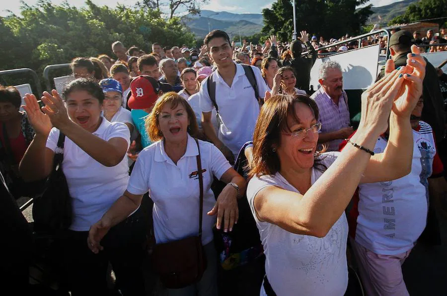 Venezolanos entusiasmados aplauden al cruzar la frontera con Colombia para comprar alimentos. 