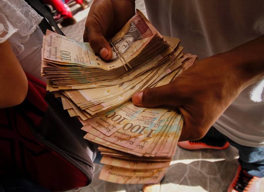 Un venezolano enseña varios billetes necesarios para comprar en Colombia debido a la inflación
