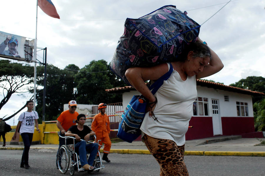 Un venezolano sufre con el peso de una bolsa llena de productos básicos