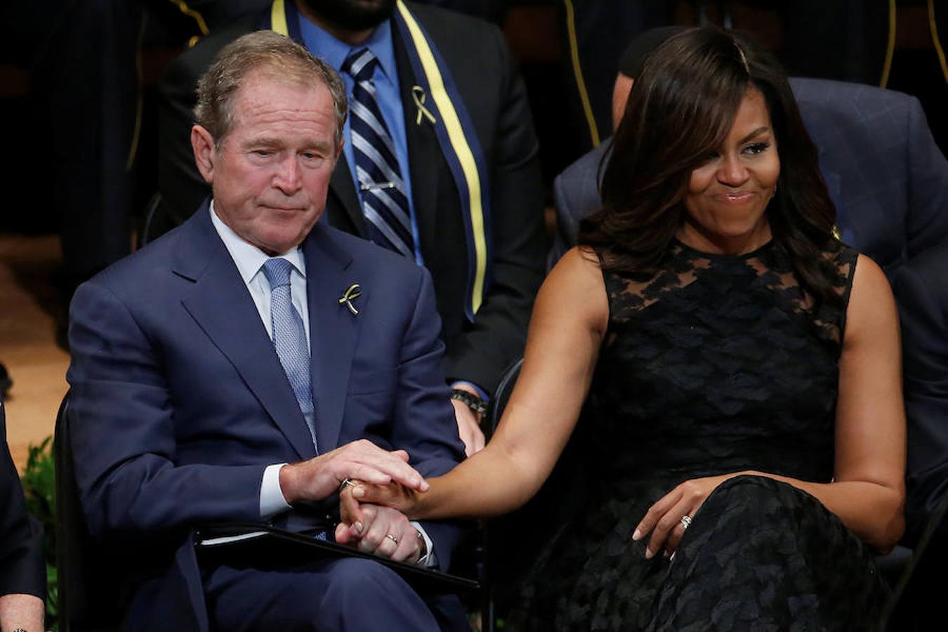 La actual primera dama de Estados Unidos, Michelle Obama, da la mano al ex presidente del país, George Bush. 