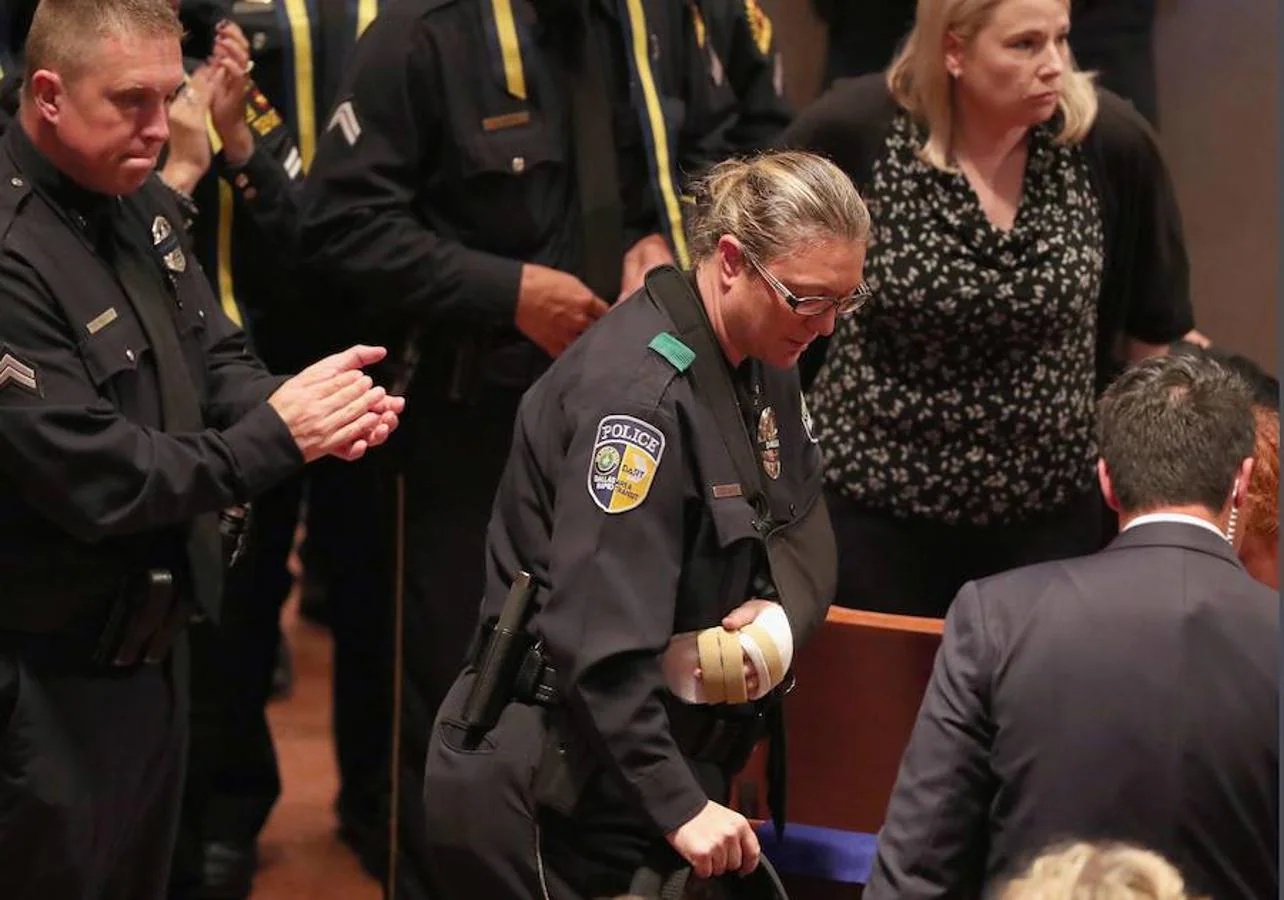 La agente Misty McBride, herida durante el tiroteo, toma asiento antes de que comience el funeral