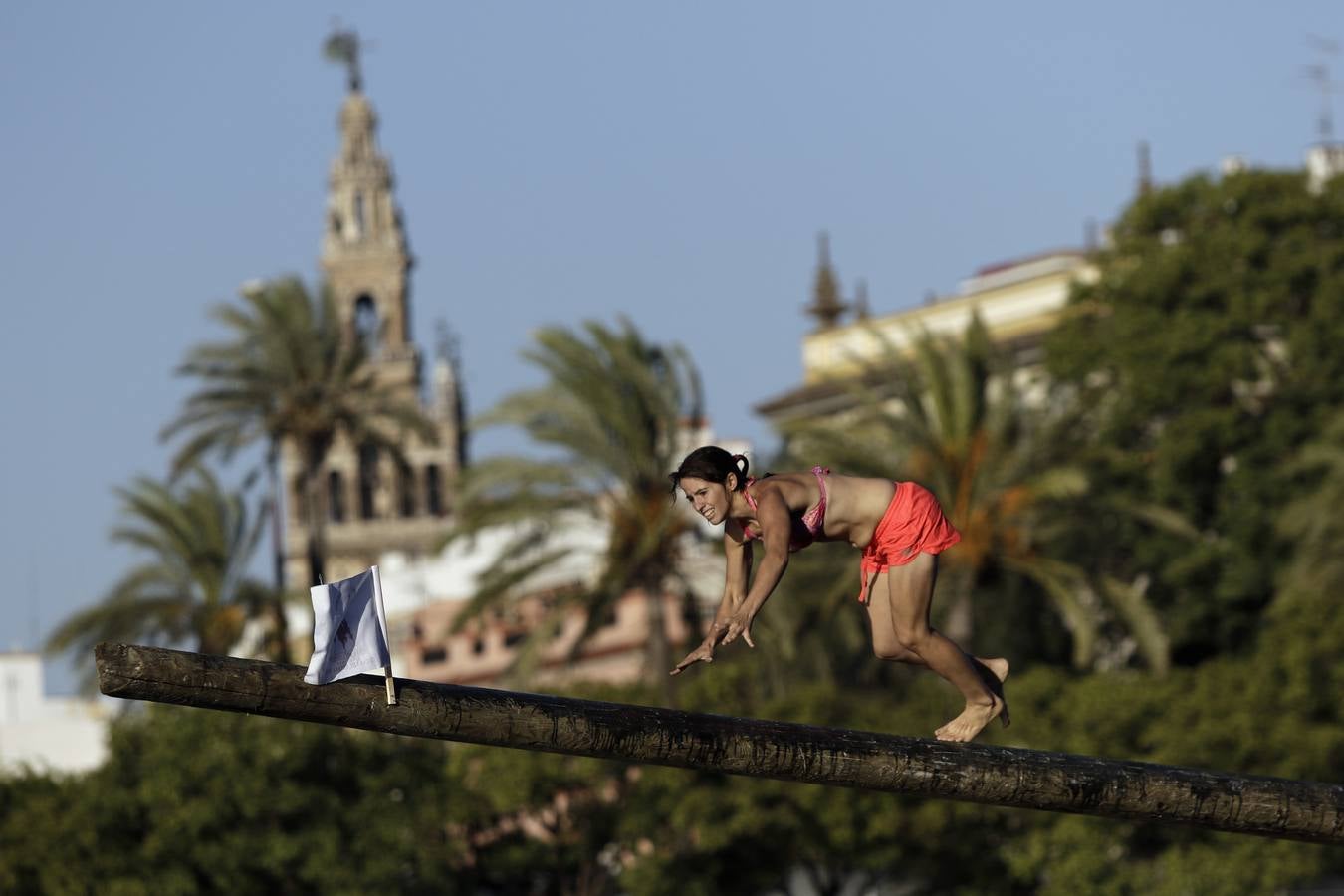 El poste se coloca horizontalmente sobre la proa de una barcaza en el río Guadalquivir