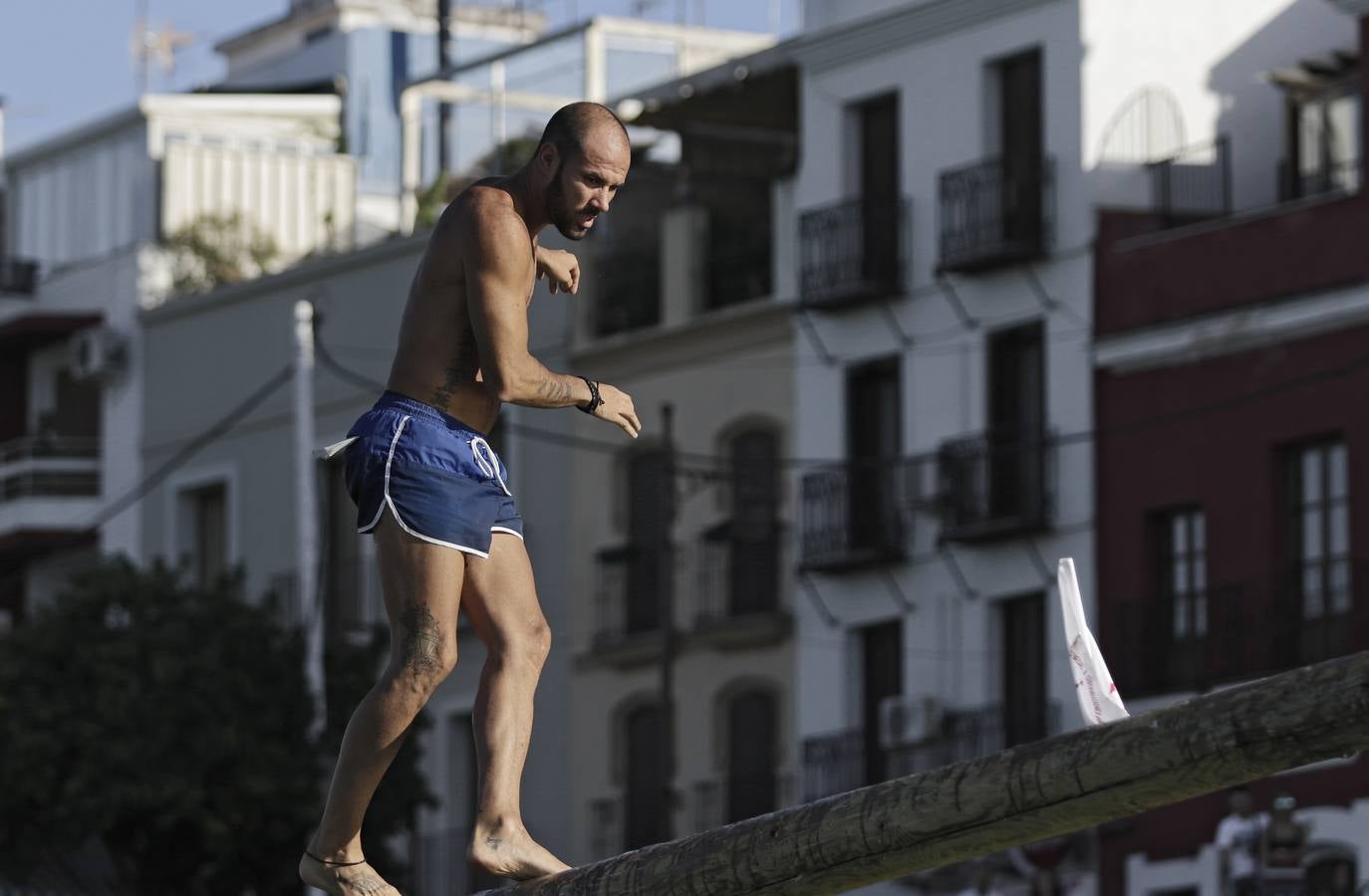 Los participantes deben caminar sobre el poste, previamente embadurnado con grasa resbaladiza, evitando caer al agua, hasta alcanzar el banderín del otro extremo