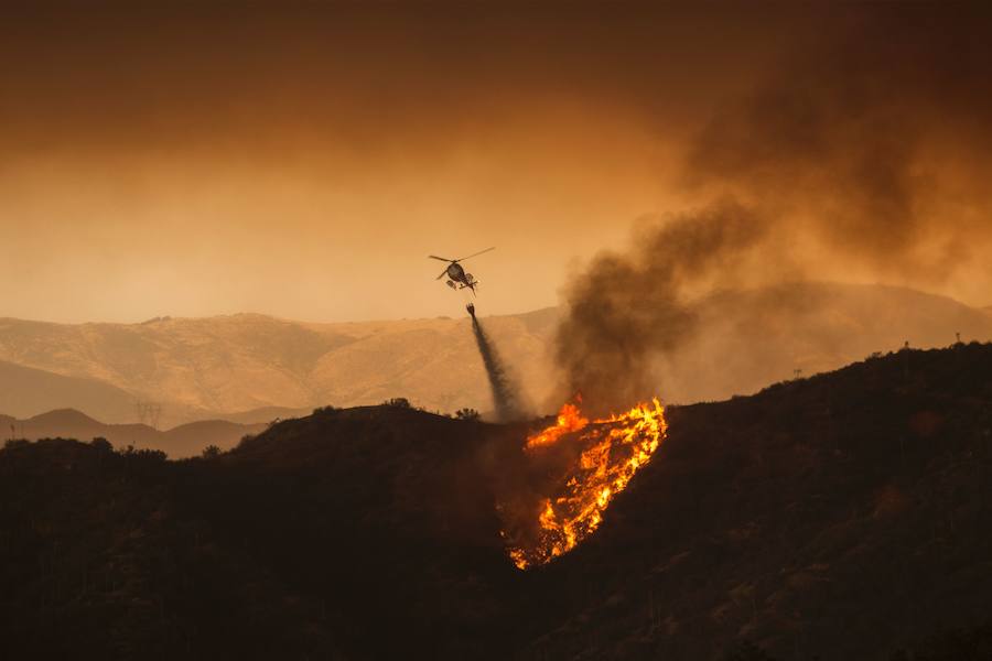 Un helicóptero arroja agua sobre «Sand Fire». 