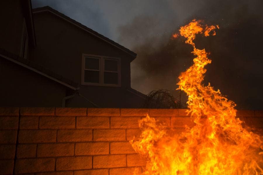 Las llamas trepan el muro de una de las viviendas afectadas en Santa Clarita