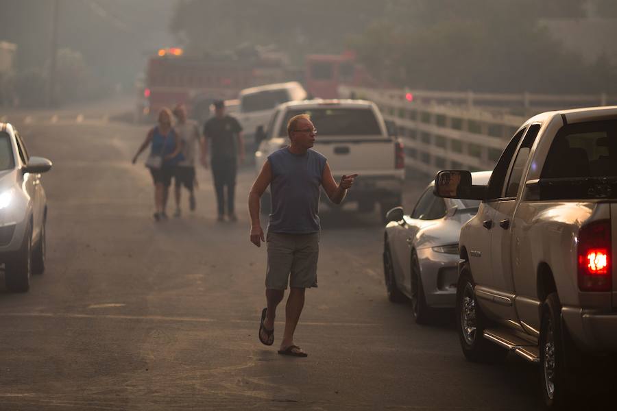 Los residentes huyen de las llamas cercanas a sus viviendas. 