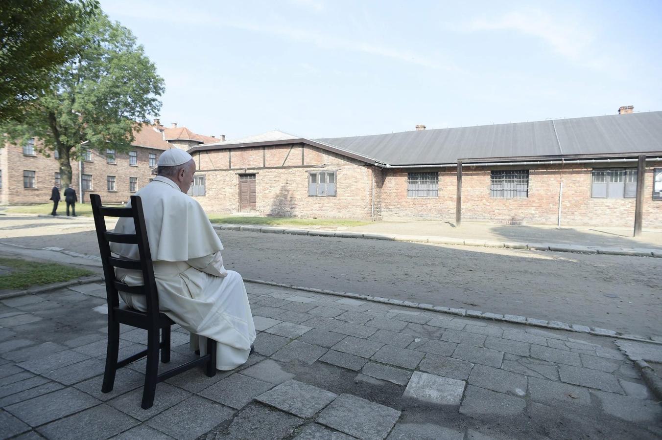 Fotografía facilitada por L'Osservatore Romano que muestra al Papa Francisco sentado frente a un barracón durante su visita al campo de concentración nazi de Auschwitz. 