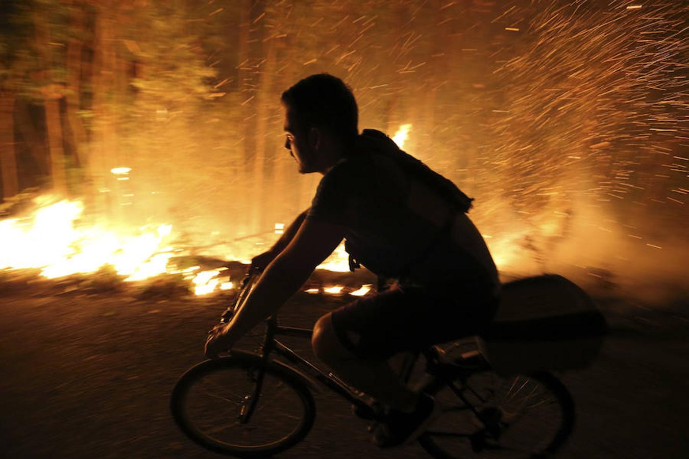 Un vecino acude para intentar sofocar las llamas del incendio forestal de Arbo (Pontevedra). 