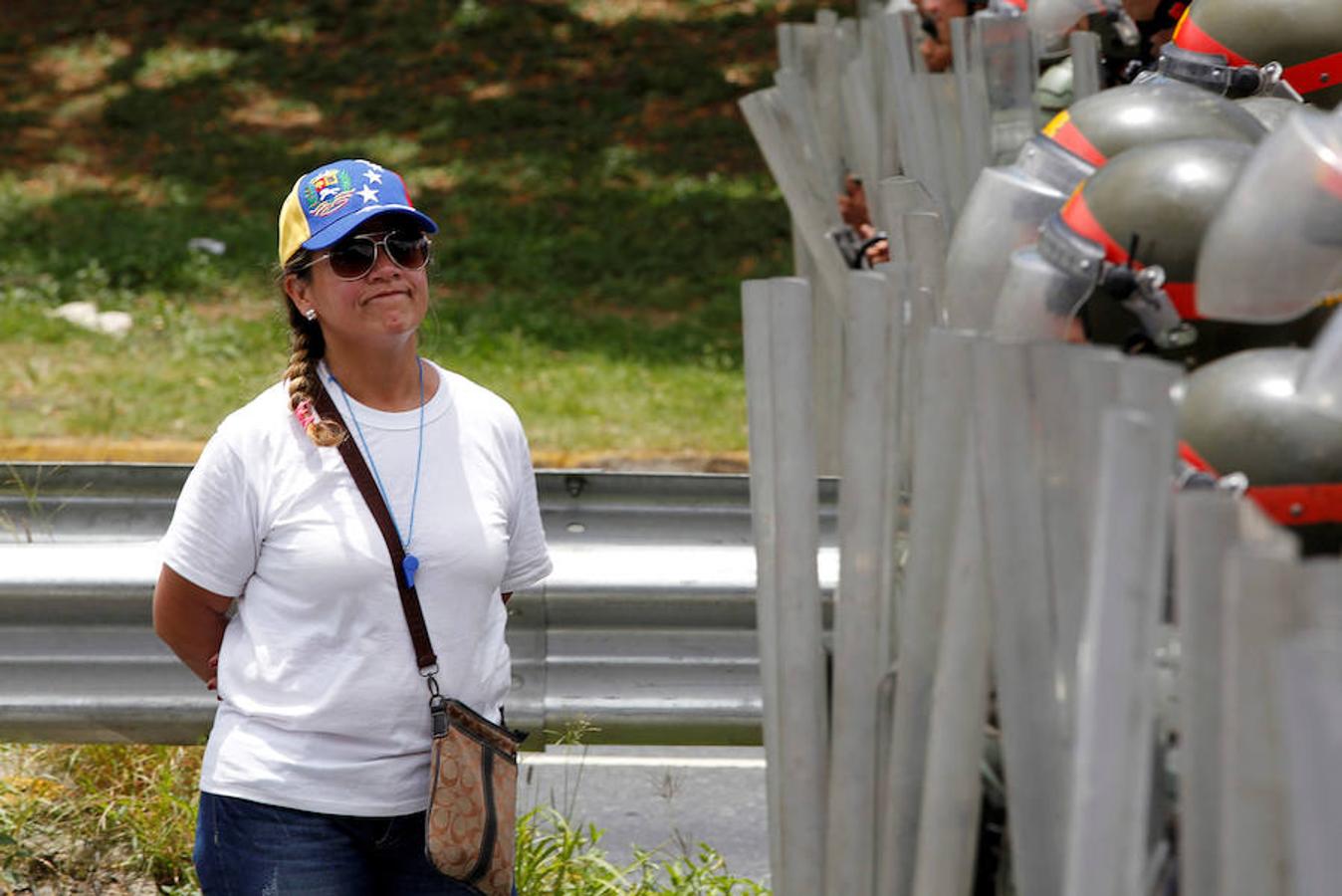 Una mujer se coloca en frente de los agentes de policía que bloquean una de las calles de acceso al centro de Caracas. 