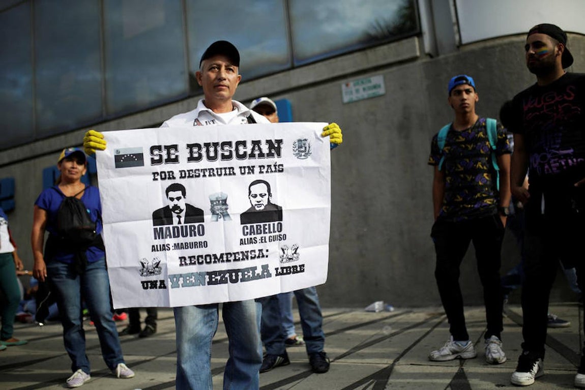 «Se buscan por destruir un país», reza el cartel que sostiene un venezola junto con los rostros de Nicolás Maduro y Diosdado Cabello. 
