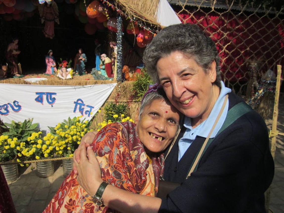 La voluntaria española Montse Alonso, ante un Belén junto a una de las enfermas que atienden las Misioneras de la Caridad de Calcuta en la Casa de Premdan. 