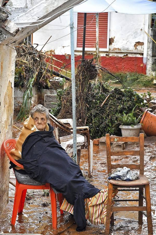 Una mujer descansa sobre unas sillas en medio del destrozo causado por las inundaciones en Kalamata (Grecia).