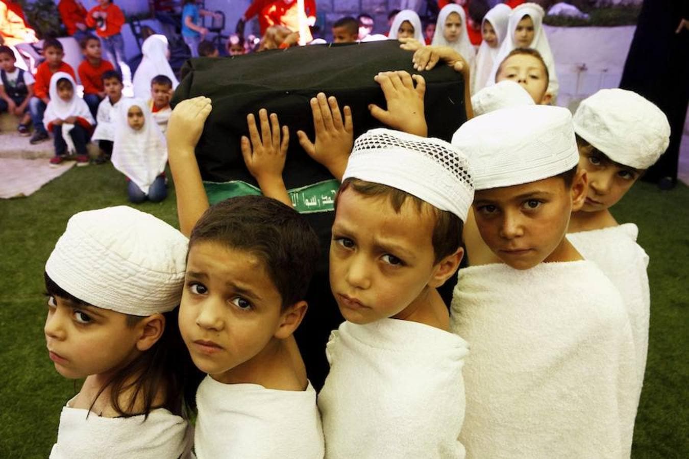 Niños sostienen un pilar que representa la «Kabaa» durante una clase sobre el «Haj» o peregrinación a la Mecca en un colegio en Hebrón (Palestina)