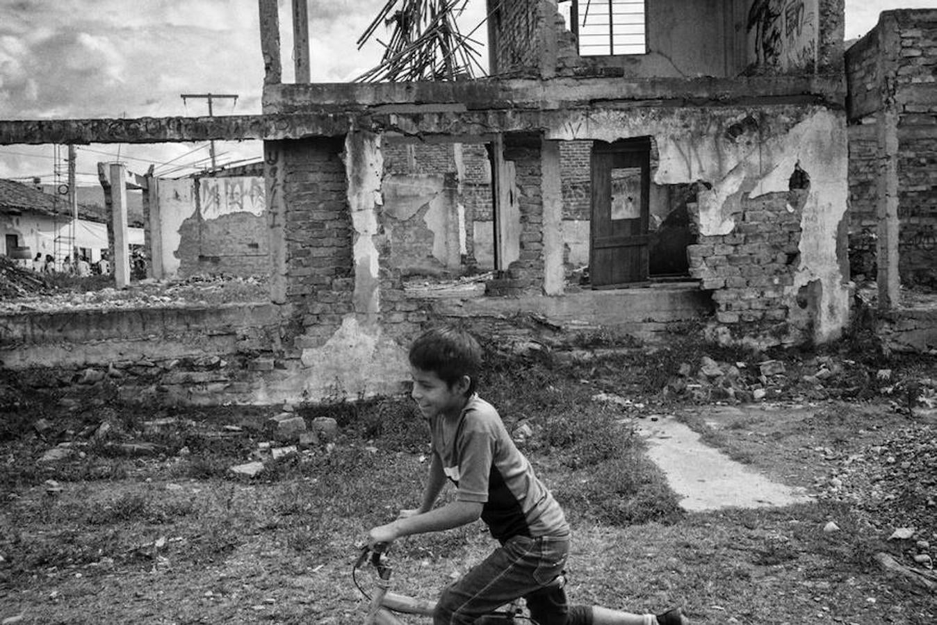 Un niño va en bicicleta frente alas ruinas de una casa destruida por un ataque de las FARC-EP en la comunidad de Toribío. 