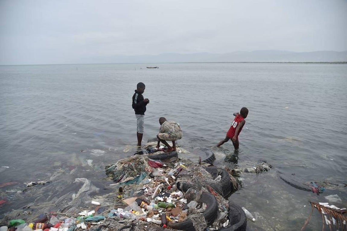 Niños juegan con la basura arrastrada por el huracán hacia la playa en Haití. 