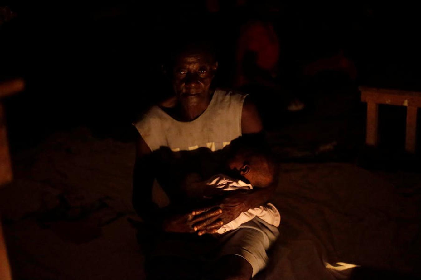 Una abuela arrulla a su nieto en el Instituto Philippe Guerrier, utilizado como refugio durante el paso del Huracán Matthew, en Les Cayes, Haití