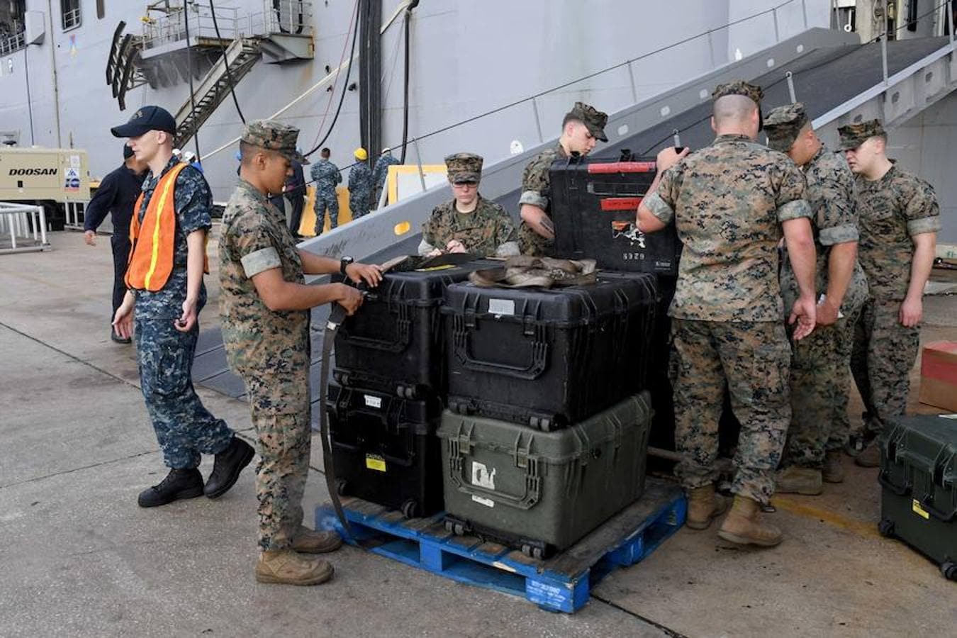 Miembros del cuerpo de marines toman precauciones respecto al equipo de su barco, antes de que llegue el huracán a Florida