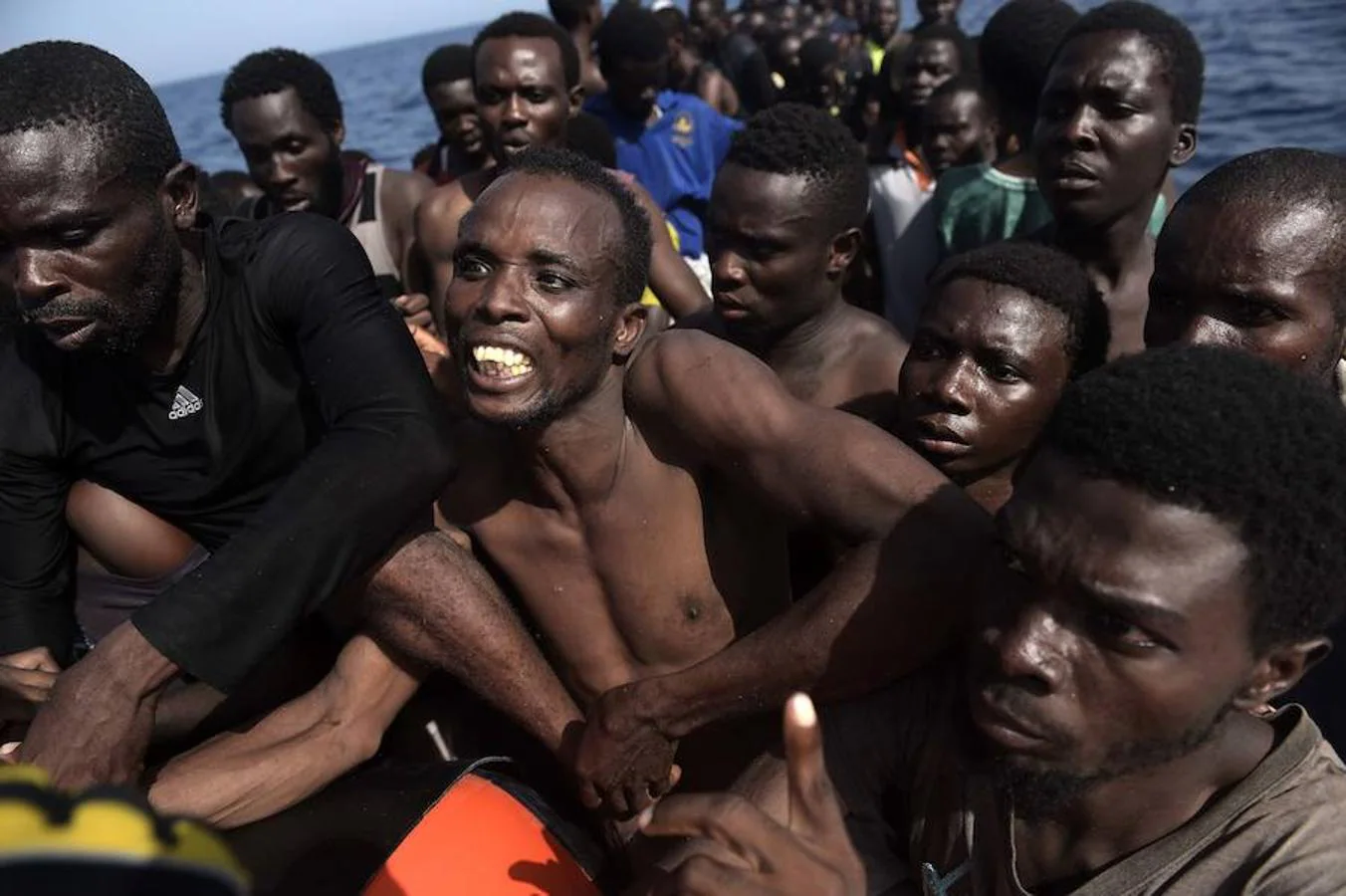 Los inmigrantes se arraciman en espera de ser traspasados a los barcos de auxilio