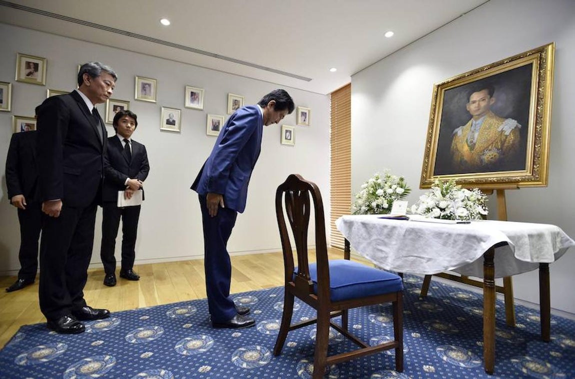 El primer ministro japonés, Shinzo Abe, hace una reverencia ante el retrato del Rey Bhumibol Adulyadej de Tailandia tras firmar en el libro de condolencias instalado en la Embajada de Tailandia en Tokio. Efe