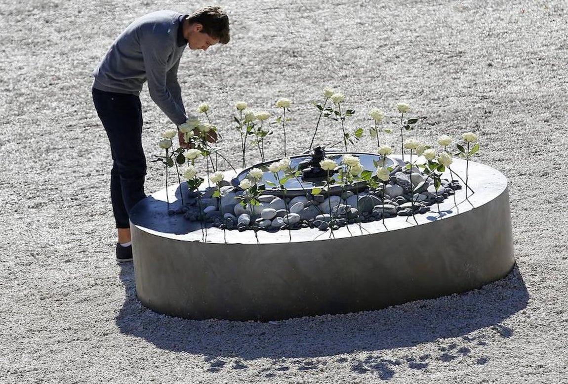 Un joven, durante la colocación de una rosa blanca. 