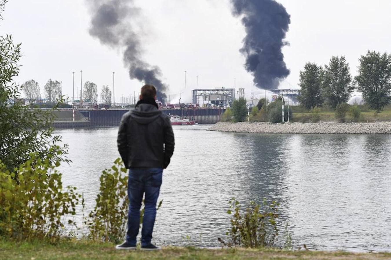 Un hombre observa como los bomberos intentan apagar las llamas en el recinto de la compañía Basf en Ludwigshafen (Alemania).