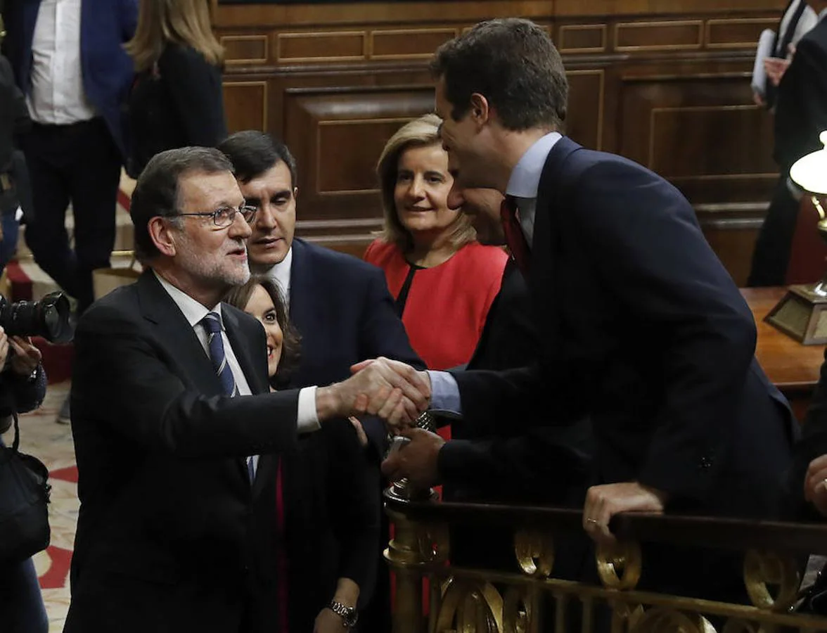 El presidente del Gobierno en funciones y líder del PP, Mariano Rajoy, saluda al vicesecretario de Comunicación del partido, Pablo Casado, a su salida del hemiciclo tras su discurso de investidura.. 