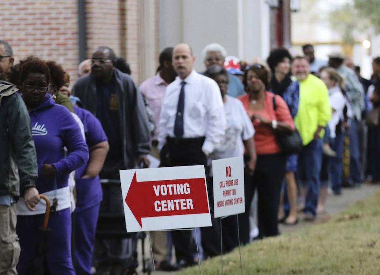 Varias personas esperan su turno para ejercer su derecho al voto en un colegio electoral durante la jornada de elecciones presidenciales en Estados Unidos, en Mobile (Alabama, EE.UU.)