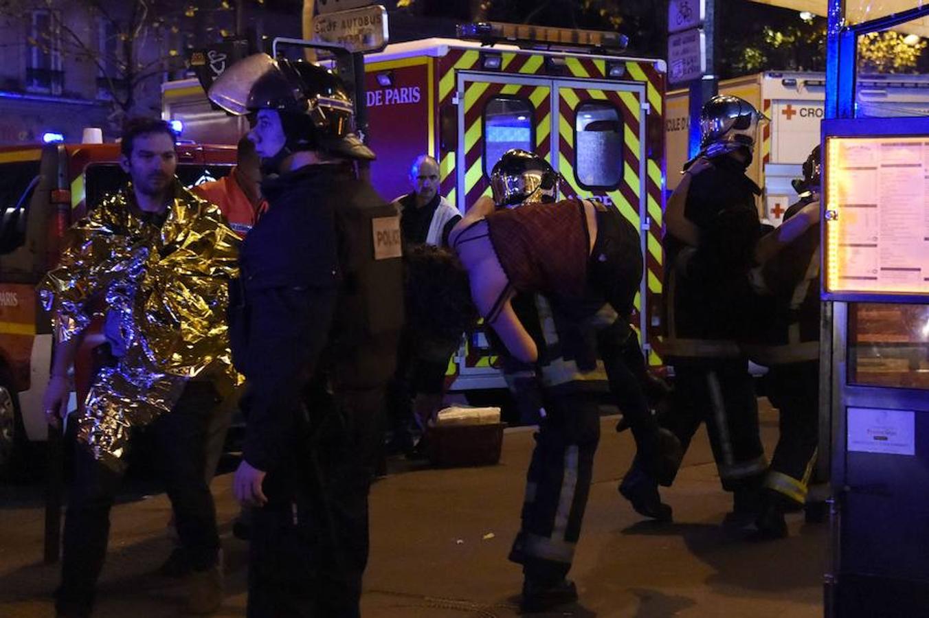 Los equipos de emergencia evacúan a una mujer en las inmediaciones de Bataclan. 