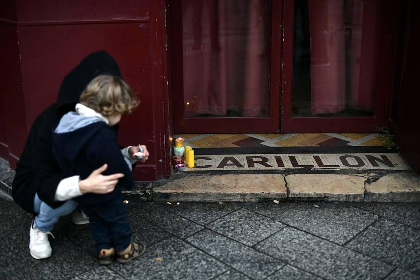 Una mujer y un niño dejan velas en el restaurante «Le Carillon» como homenaje a las víctimas del ataque terrorista en París el 13 de noviembre de 2015. 