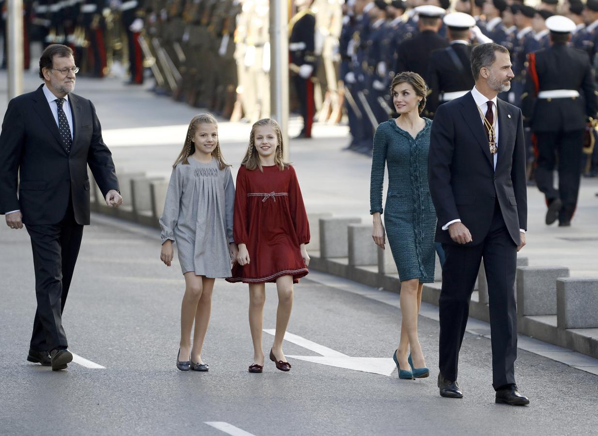 El Rey Felipe VI, acompañado de la Reina Letizia y de sus hijas, la princesa de Asturias, Leonor, y la Infanta Sofía, y del presidente del Gobierno, Mariano Rajoy (i), a su llegada al Palacio de las Cortes donde preside hoy la solemne ceremonia de apertura de la XII Legislatura 