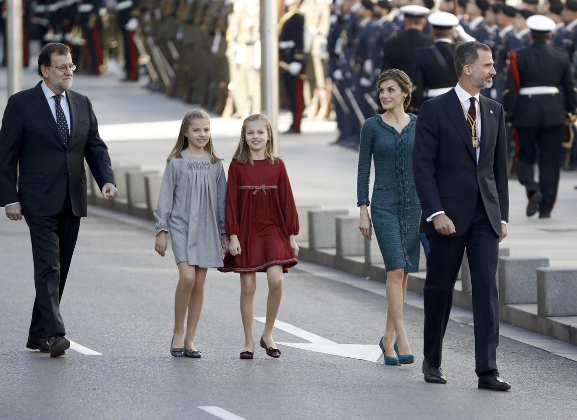 El Rey Felipe VI, acompañado de la Reina Letizia y de sus hijas, la princesa de Asturias, Leonor, y la Infanta Sofía, y del presidente del Gobierno, Mariano Rajoy (i), a su llegada al Palacio de las Cortes donde preside hoy la solemne ceremonia de apertura de la XII Legislatura. 