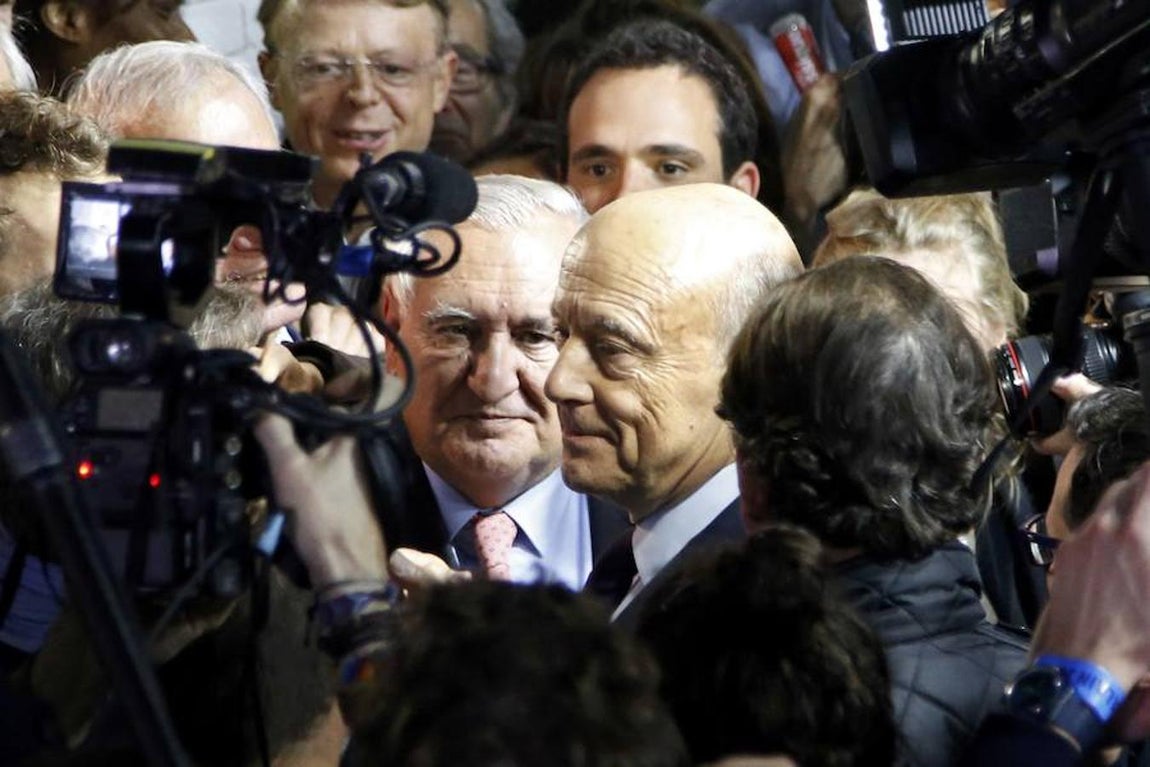 El antiguo primer ministro y delfín de Jacques Chirac Alain Juppé bajo la atenta mirada del político francés Jean-Pierre Raffarin tras conocer los resultados de la primera vuelta de las elecciones primarias de la derecha gala.. 