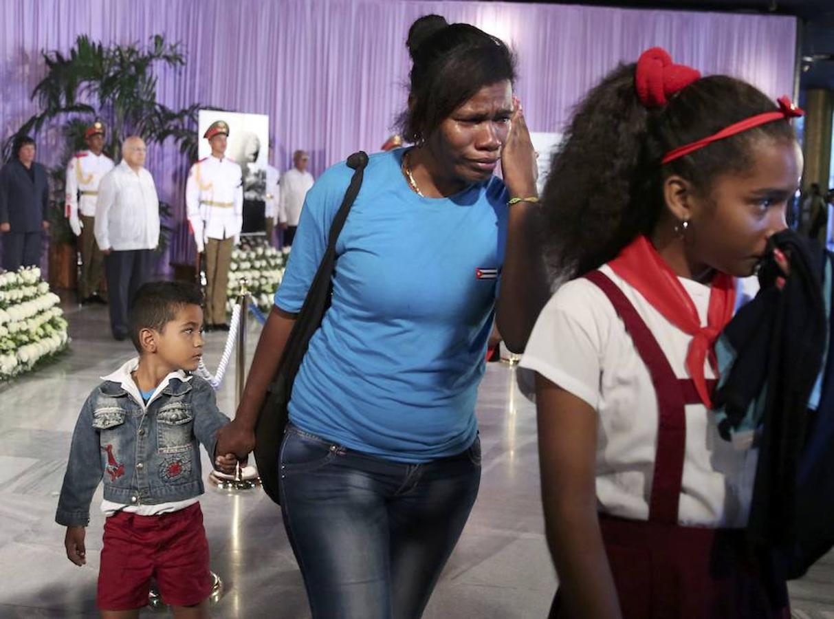 Muchos trabajadores de centros de trabajo, escolares con sus uniformes y familias con sus hijos formaban una fila en la que reinaba el silencio que solo se rompía por gritos de «Viva Fidel».