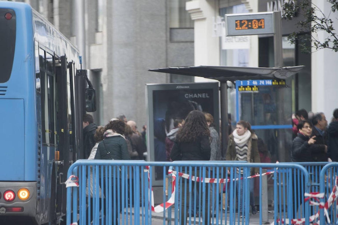 Varias personas esperan el autobús este sábado en la Gran Vía cortada. 