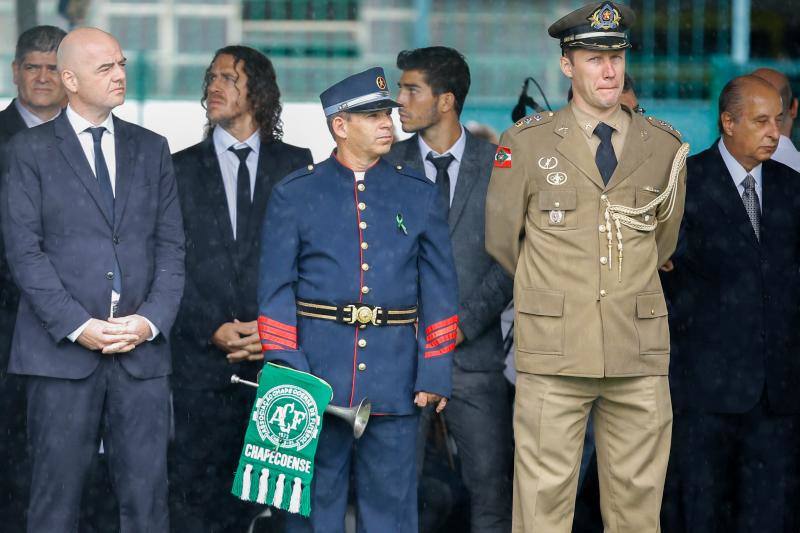 El presidente da FIFA Gianni Infantino (i), el exjugador español Carles Puyol (3i), el jugador de Real Madrid Lucas Silva (3d) y el presidente de CBF Marco Polo Del Nero (d) son vistos junto a féretros de los jugadores y equipo técnico del club brasileño Chapecoense. 