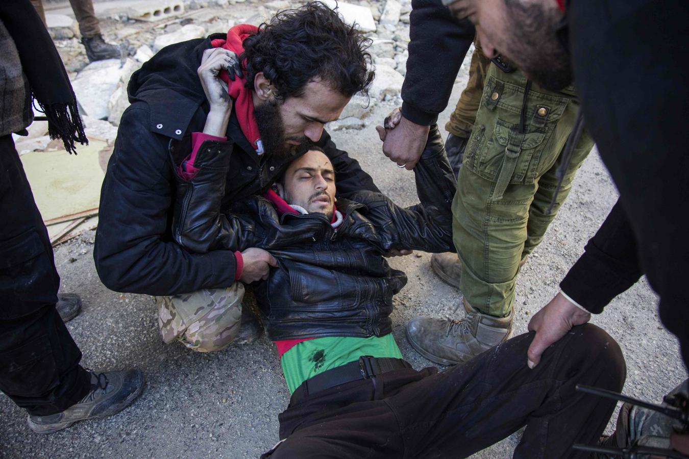 Un hombre herido recibe ayuda mientras los rebeldes sirios y sus familias abandonan el este de Alepo. 