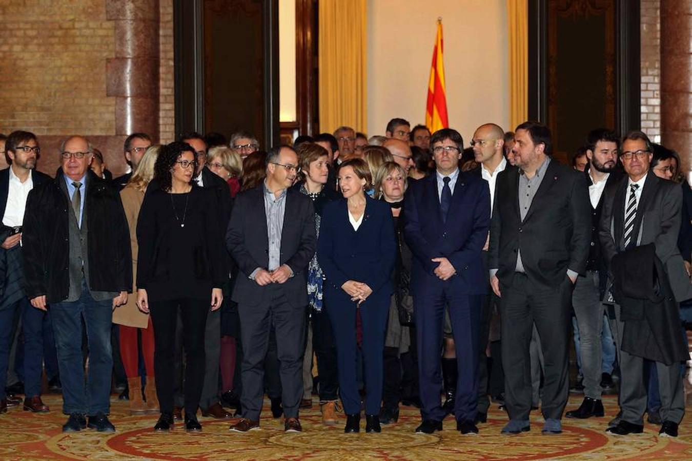 La presidenta del Parlament, Carme Forcadell, acompañada por el presidente de la Generalitat, Carles Puigdemont; el vicepresidente Oriol Junqueras; el expresidente Artur Mas, otros miembros del gobierno catalán y otros cargos electos del soberanismo, en el Parlament poco antes de salir hacia el TSJC