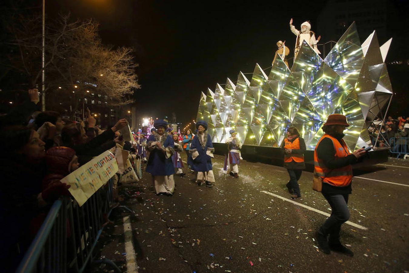 La llegada de los Reyes Magos a Madrid, en imágenes. El rey Melchor saluda a unos niños con cárteles en los que aseguran que se han portado bien. Y, ¿vosotros?