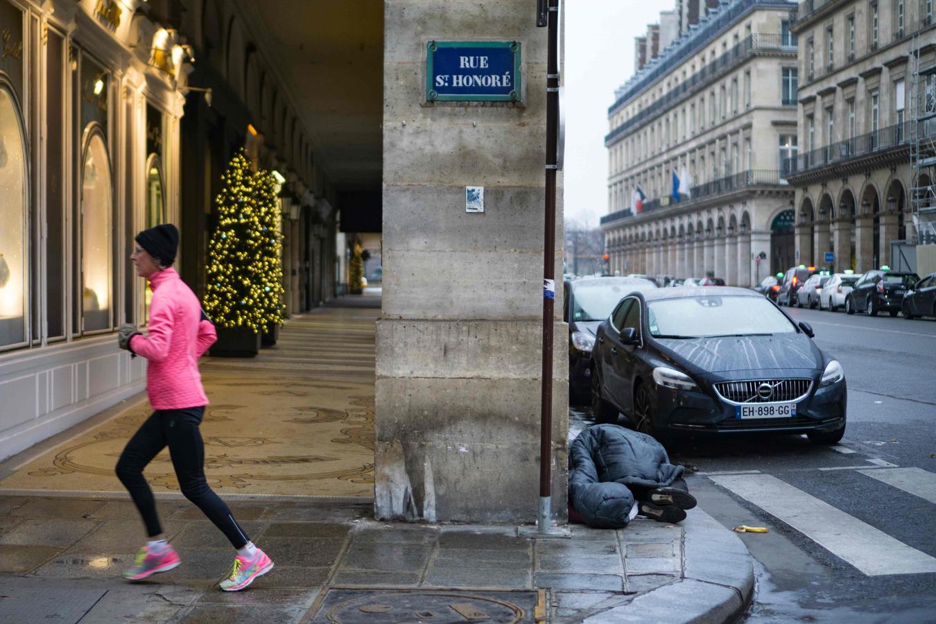 Un hombre sin hogar duerme en una céntrica calle de París a pesar de la ola de frío que recorre Europa