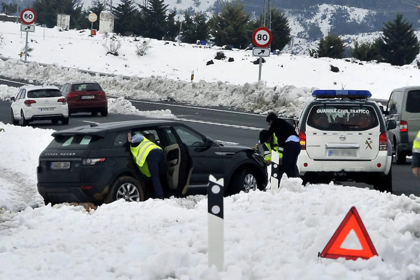 La Guardia Civil ayuda a un vehículo salido de la carretera en la localidad de Almansa, las intensas nevadas caídas que complican las comunicaciones por carretera y tren