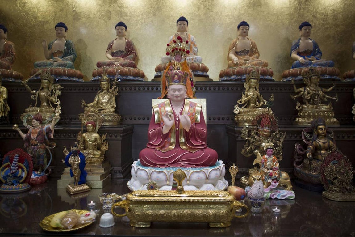 7. En el altar principal del templo budista tibetano de Usera aparecen, entre otras, la figura central de Bodhisattva, junto con las ofrendas que los fieles les dejan.