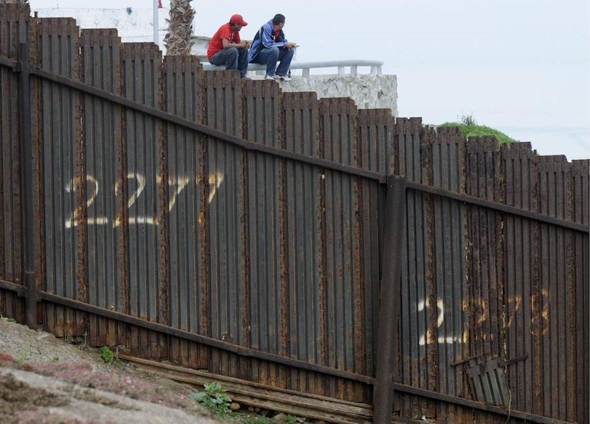 Dos mexicanos observam en octubre de 2010, la reja que separa México y Estados Unidos en San Ysidro. 