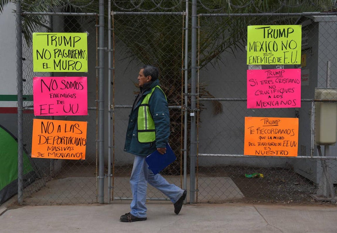 Fotografía de letreros con mensajes relacionados a la investidura de Donald Trump como presidente de los Estados Unidos, el 20 de enero de 2017, en el paso migratorio de Mexicali, frontera de Tijuana con Caléxico (Estados Unidos). 